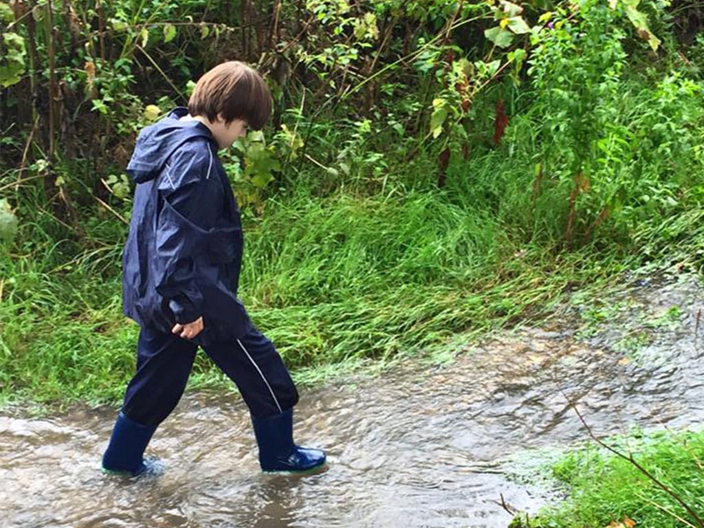 Child walking through stream