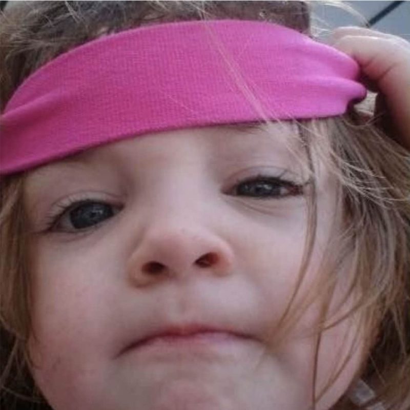 Girl with pink band with FASD looking at camera